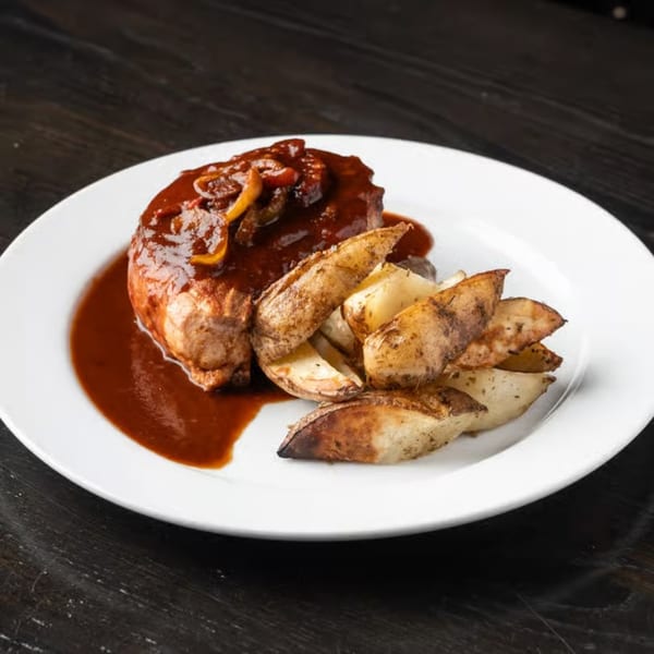Gabagool Wine Bar's steak with rich brown sauce and roasted potato wedges on a white plate.